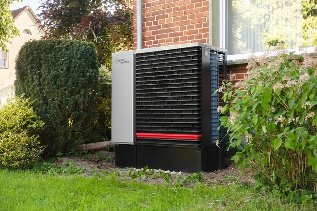 Energy-efficient heat pump in a green residential garden setting. Quebec dual-energy rate: is a heat pump cheaper than baseboards in Montreal?
