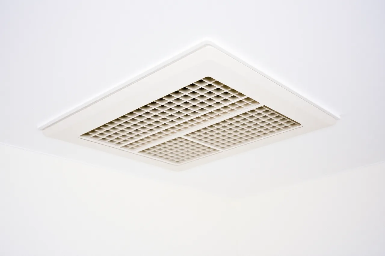 Ceiling supply register with louvers angled to direct airflow (Daily habits change in specific ways after a heat pump replaces a furnace)